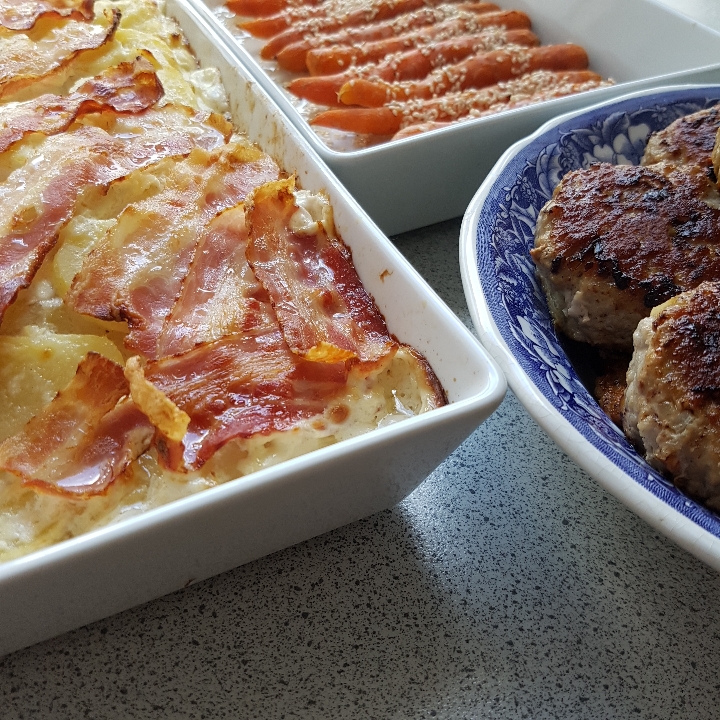 Frikadeller, baconflødekartofler og sesamgulerødder.