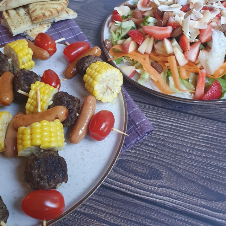 Grillspyd med kødboller, grøntsager og pølser - serveret med blandet salat